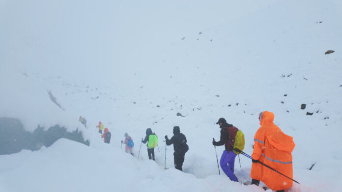 A screen capture from video shows trekkers leaving their campsite, as unusually heavy snow and rainfall pummeled the Himalayas, in the Tibet Region