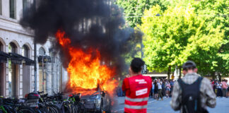 Protestatarii incendiază un Tesla și sparg geamurile unui birou ONU în timpul unui marș anti-G7 la Geneva